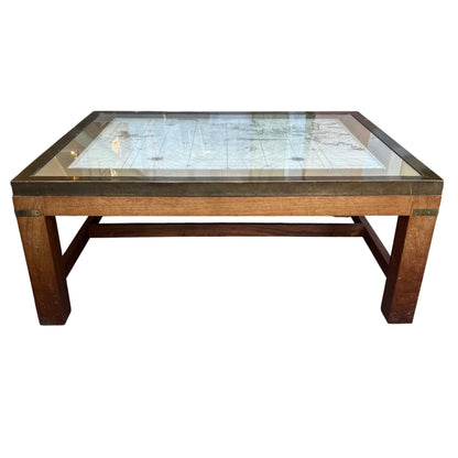 Low oak coffee table showing brass frame and clear glass top with map beneath