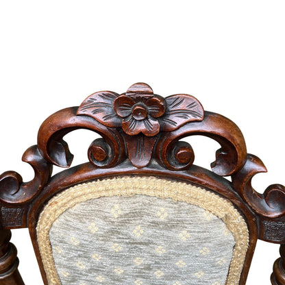 Close-up of upholstered seat with pale patterned fabric and braided trim