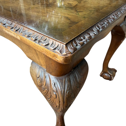 Side view of vintage coffee table with scalloped apron and carved legs