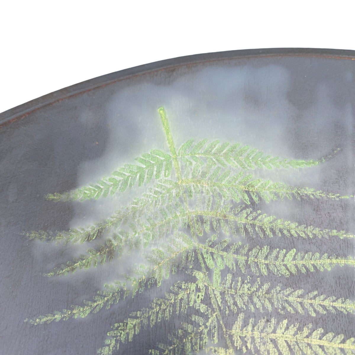Close-up of hand-painted fern decoration and distressed surface on round table top