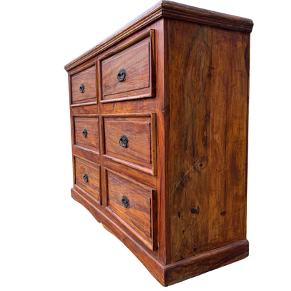 Close-up of top edge showing moulded top and worn finish of a wooden chest of drawers