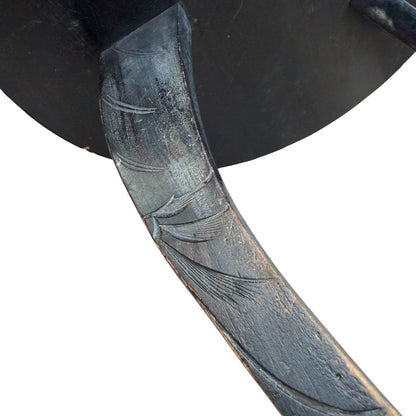 Corner detail showing small edge chip and carved surface on wooden table