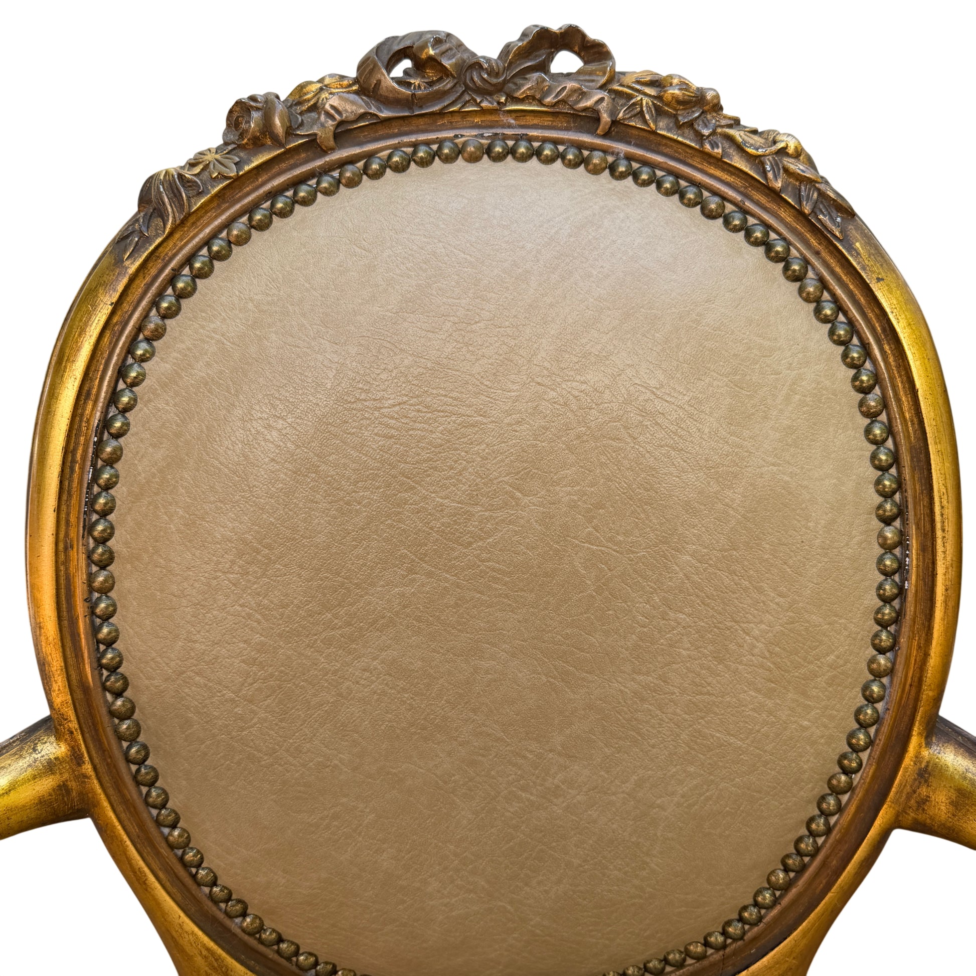 Close-up of shaped front leg and carved detail on gilt Louis-style armchair