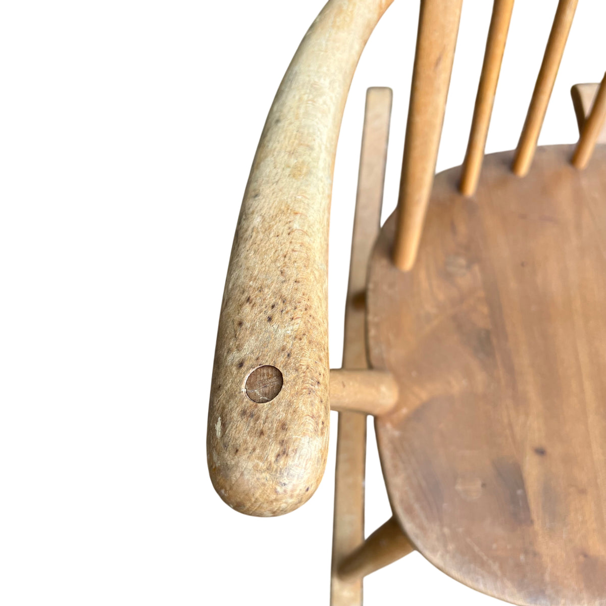 Detail of armrest and spindle joinery on a light wood vintage rocking chair