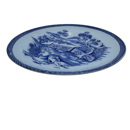 Close view of blue transferware plate border with scallop motif and central chinoiserie decoration