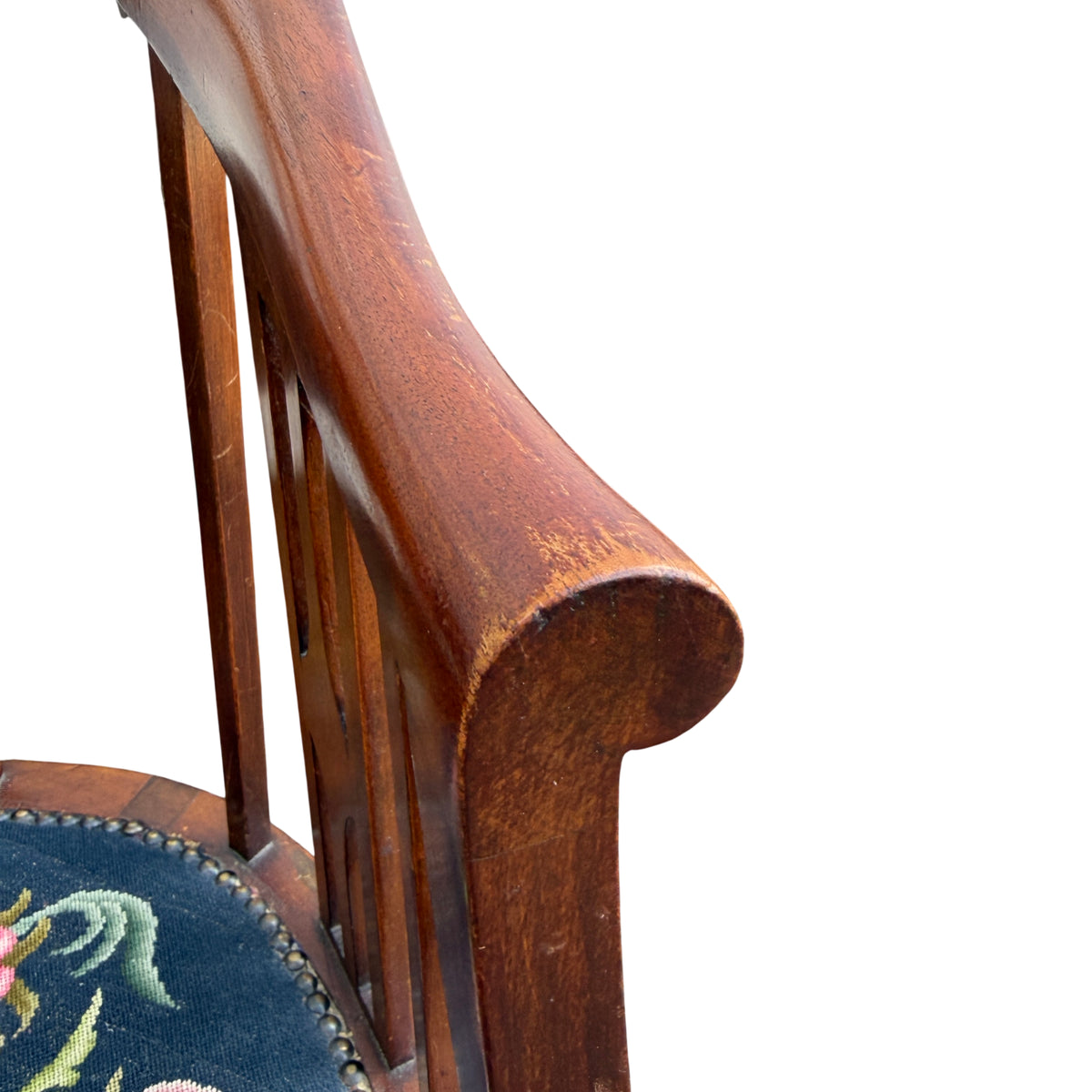Close-up of needlepoint upholstery and nailed trim on vintage armchair