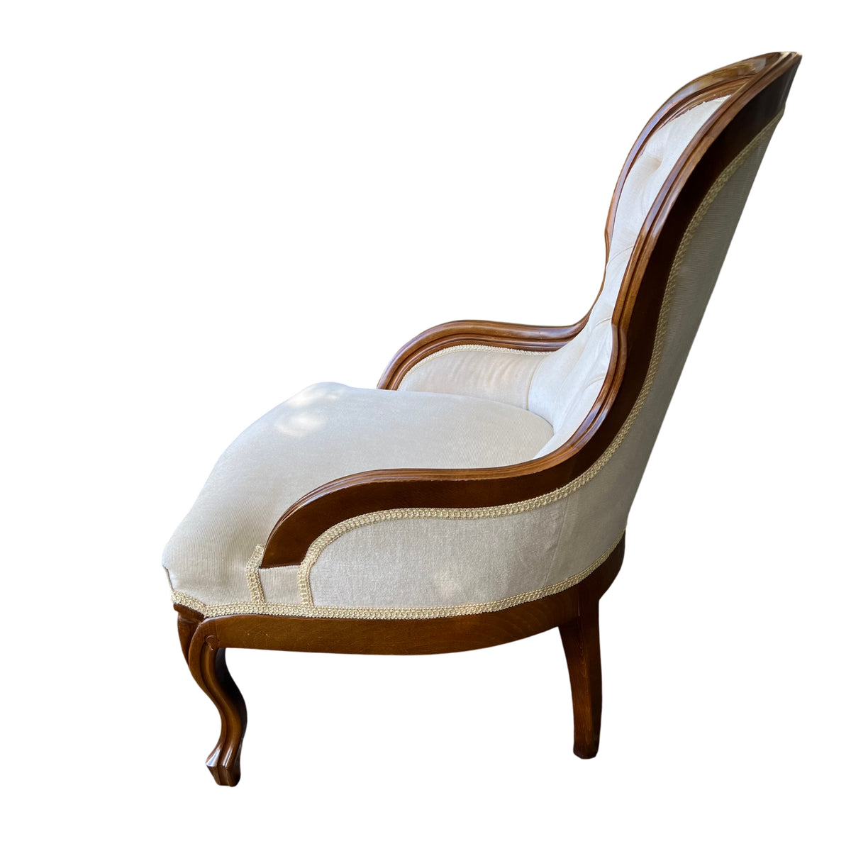 Close-up of button tufting and cream fabric on Victorian-style armchair