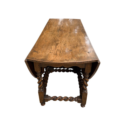 Top view of round oak dining table when fully extended, showing joins and surface marks