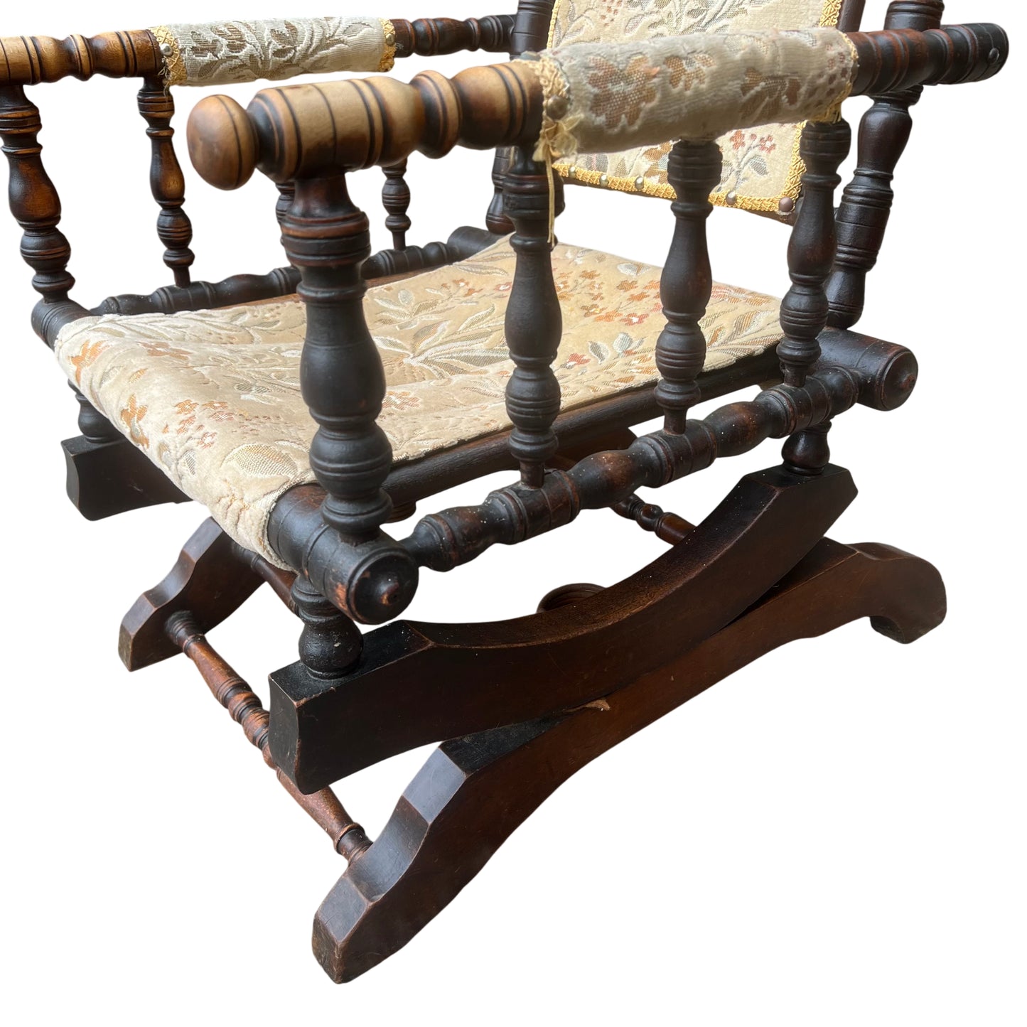 Side view of wooden curved rocker base and turned stretcher on vintage armchair