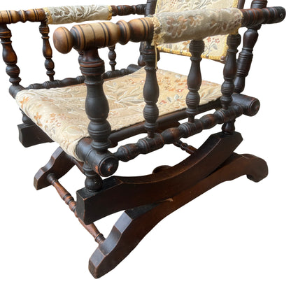Side view of wooden curved rocker base and turned stretcher on vintage armchair