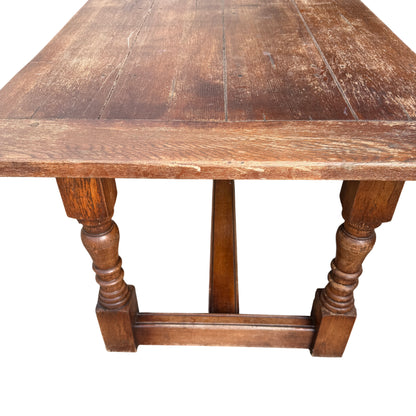 Corner of oak dining table with visible surface wear and small cracks