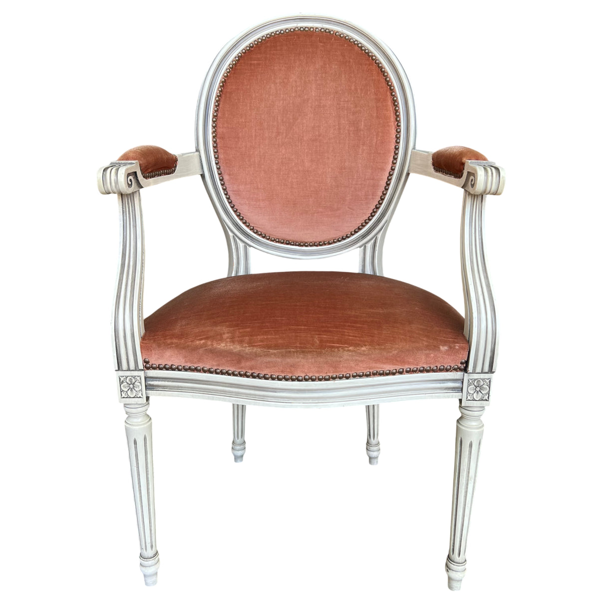 Armless view of a Louis XVI style bergère armchair with oval back and painted fluted frame