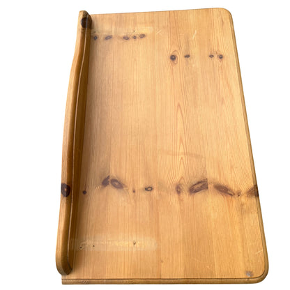 Side view showing turned legs and curved apron of pine hall table