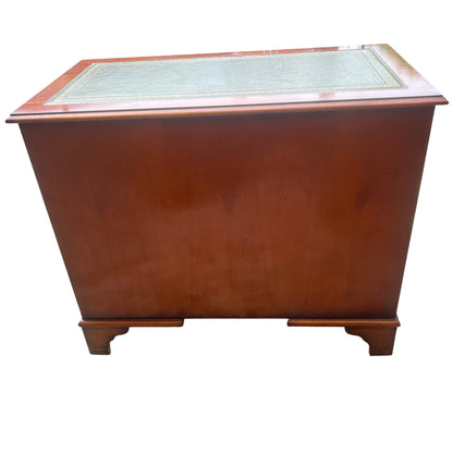 Open central cupboard of kneehole desk showing internal wood panels and key