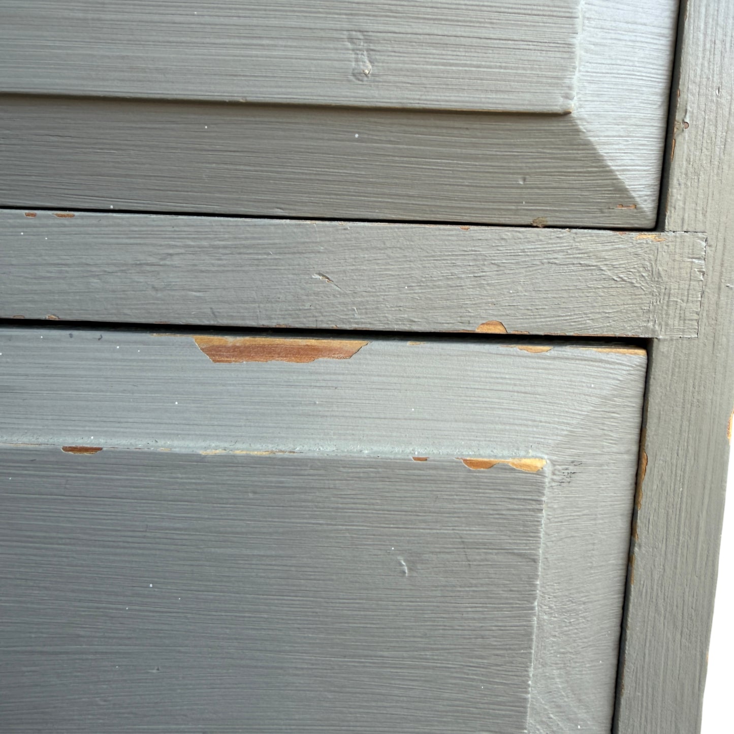 Side view of painted pine chest of drawers showing painted edge and corner chip
