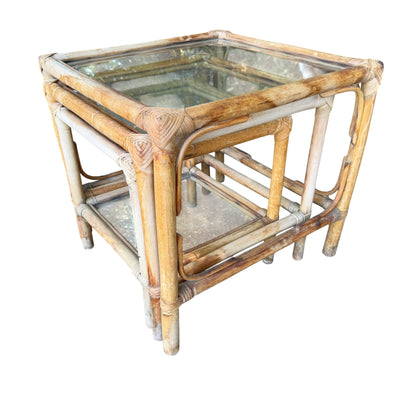 Three vintage rattan nest tables with lighter, sun-faded finish and intact glass