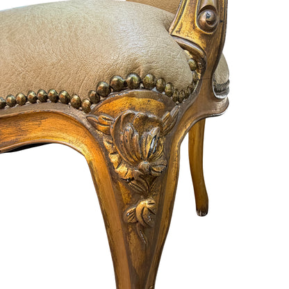 Three-quarter view of carved gilt armchair showing arm, seat and rear leg with castor