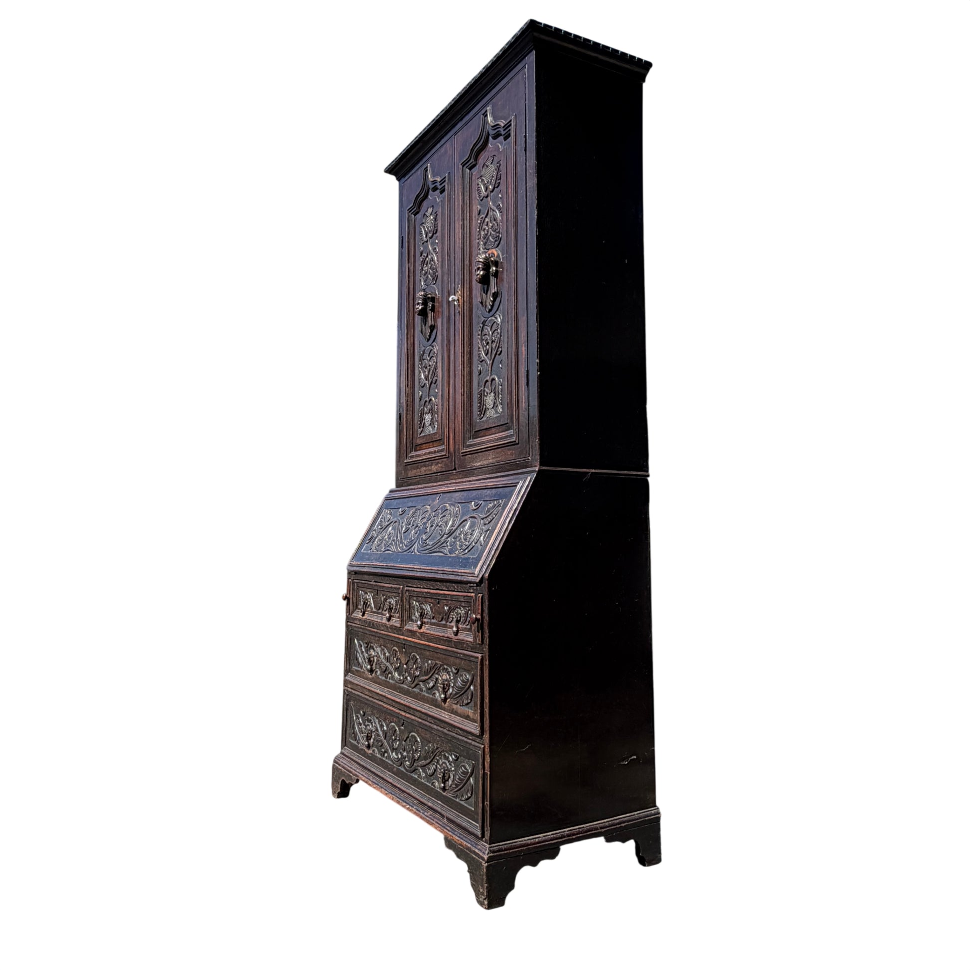 Close-up of carved fall-front secretaire panel on oak bureau