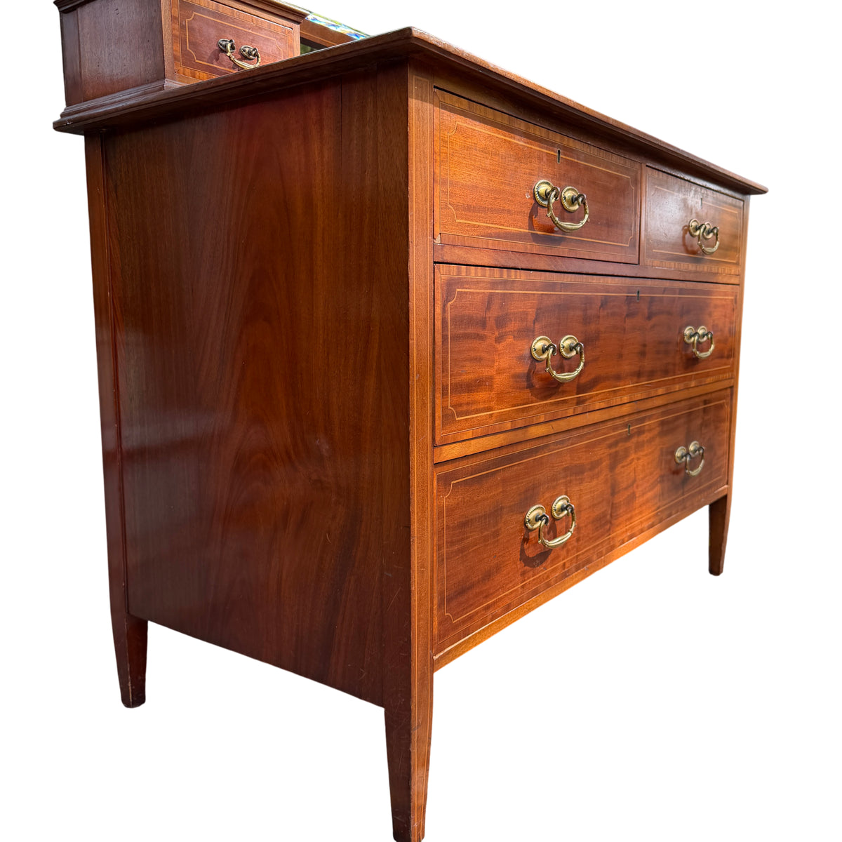 Close view of brass drop handles on vintage mahogany chest of drawers