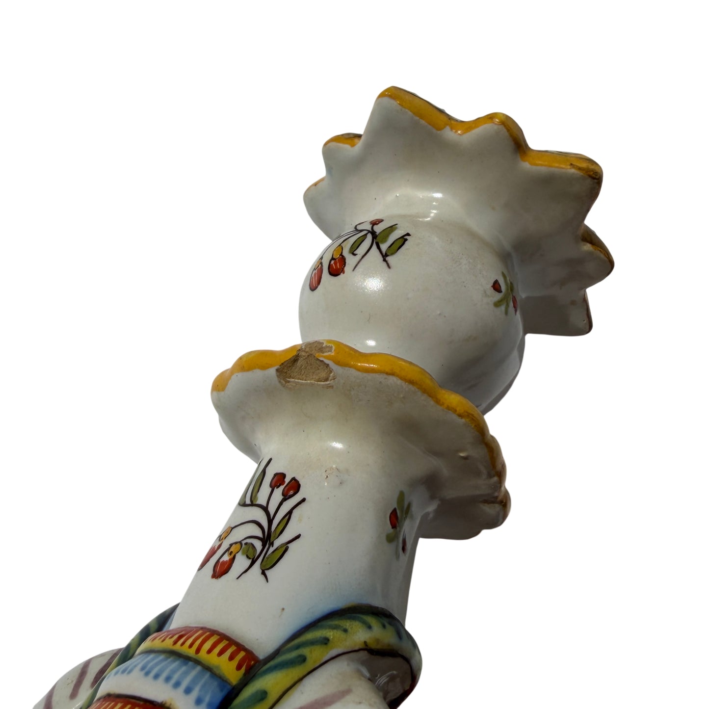Side profile of vintage hand-painted ceramic candlestick with mask and scrolls