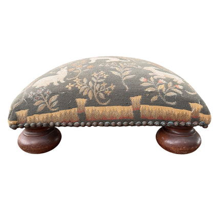 Detail of turned wooden bun foot and scuffed finish on vintage footstool