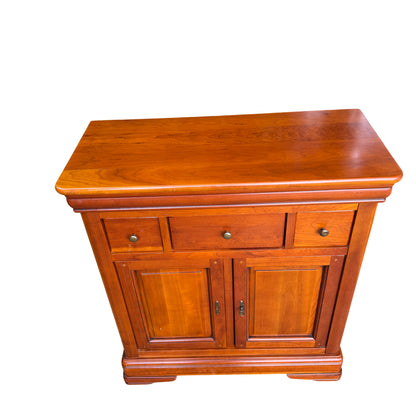 Close-up of the top drawers and round brass-effect knobs on wooden cupboard