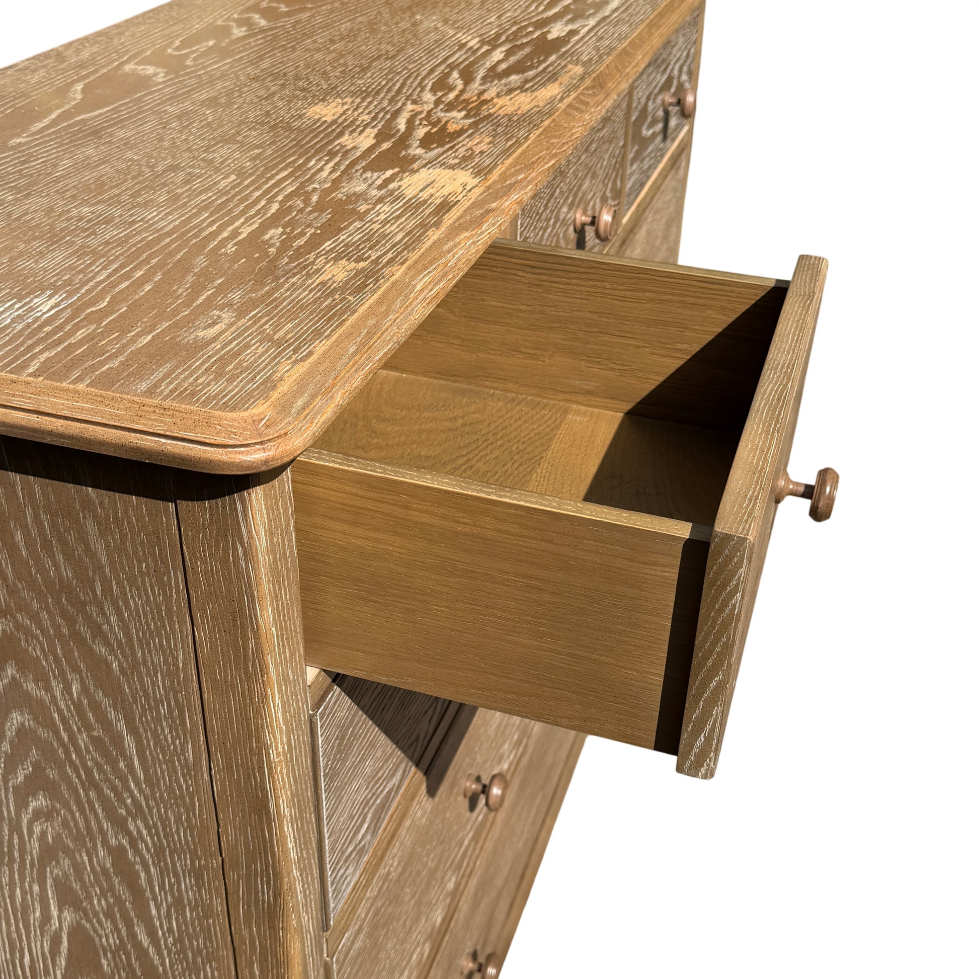 Close view of one round knob handle casting a small shadow on the drawer front