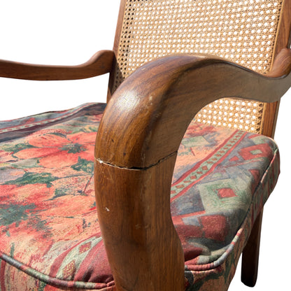 Shaped wooden arm and padded seat of vintage armchair with wear to finish