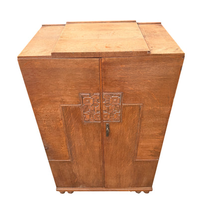 Front view carved doors on Art Deco oak cupboard with Vesper Furniture badge