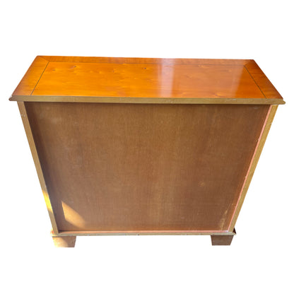 Lower shelf and base feet of compact wooden bookcase