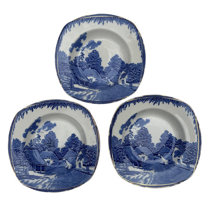 Set of three Burleigh Ware blue and white soup bowls with gilt rims and rural village transfer pattern