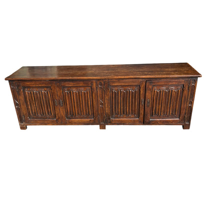 Low Victorian oak cupboard sideboard showing carved doors and moulded top
