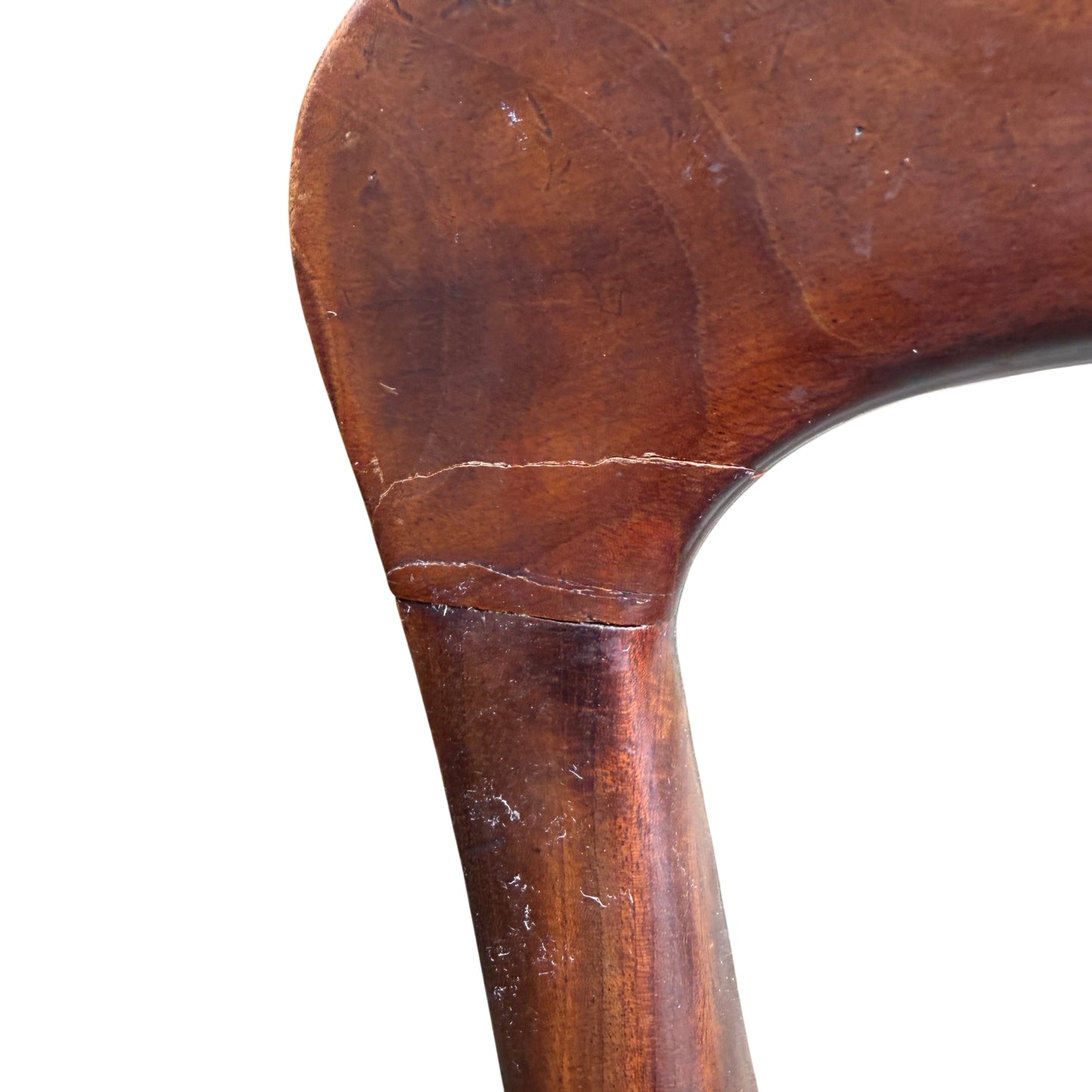 Close detail of scratched and marked mahogany top rail on dining chair