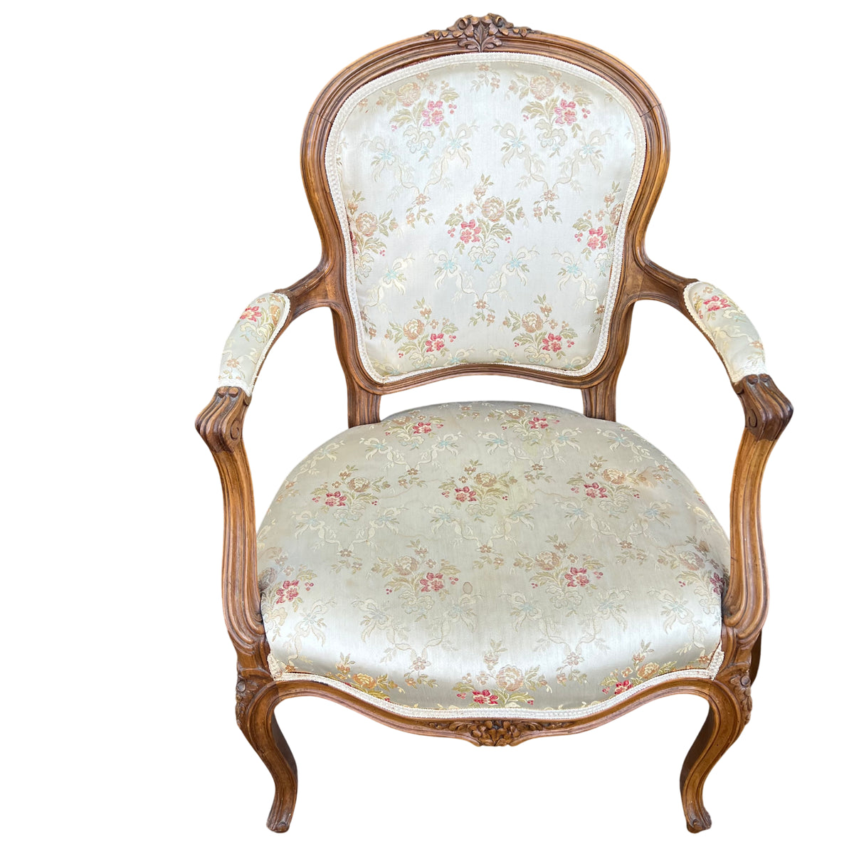 Front view of upholstered bergère armchair with carved apron and cabriole legs