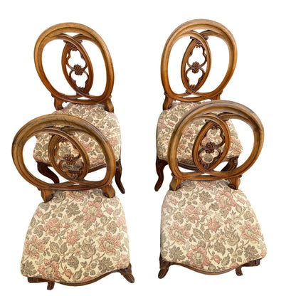 Set of four carved dining chairs with floral upholstered seats and oval backs