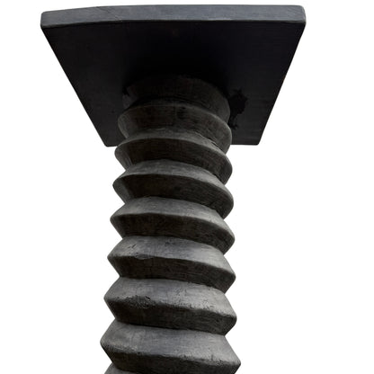 Close view of spiral-carved central shaft on wooden wine press pedestal