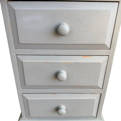 Lower drawers and turned knobs on slim vintage pine chest painted grey