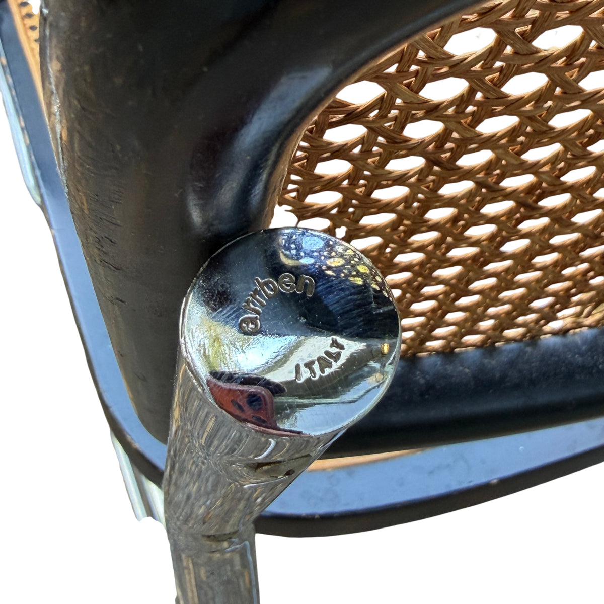 Woven cane backrest detail showing join to black timber surround on an Italian cantilever chair