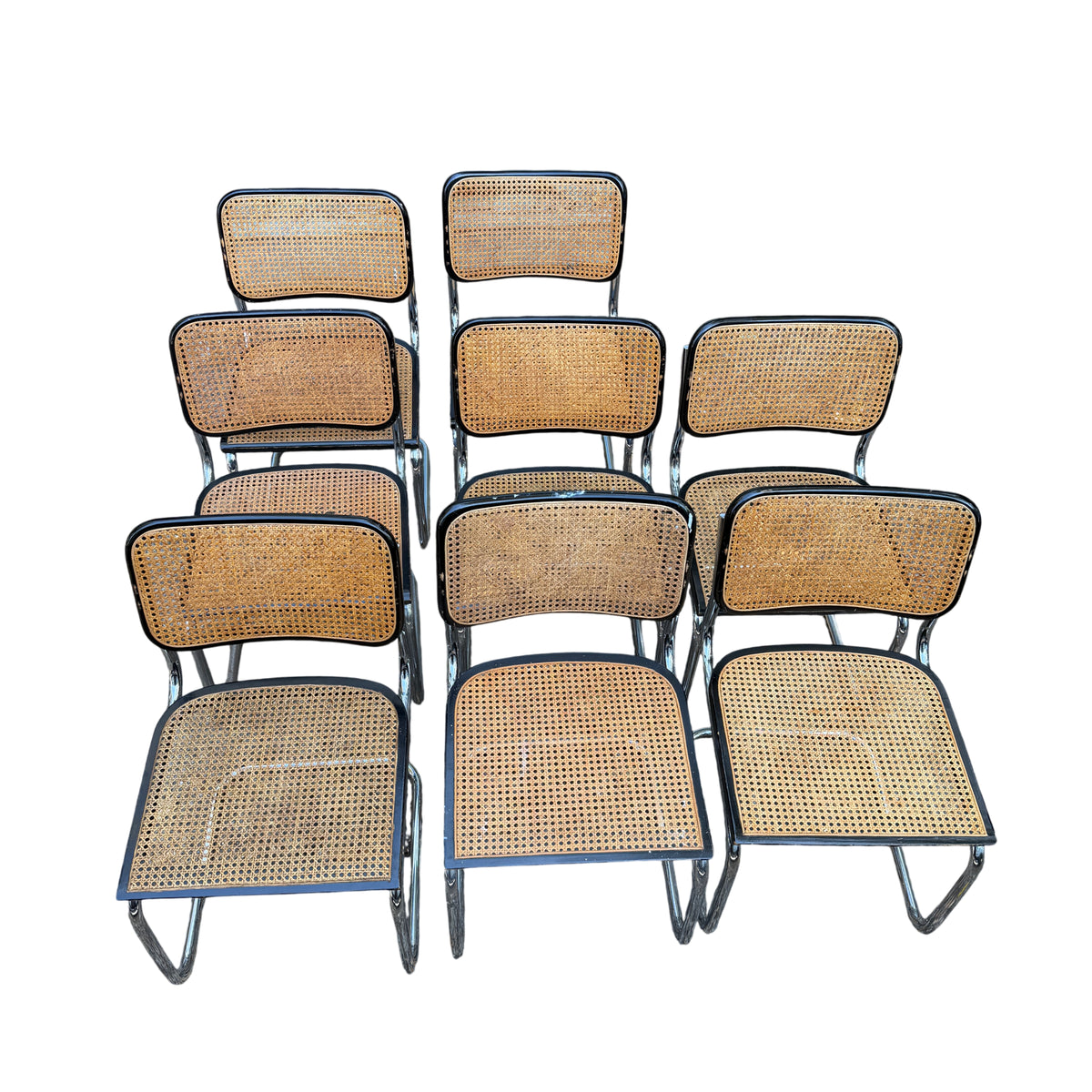 Front view of eight vintage Arrben cane dining chairs arranged in rows showing woven seats and backs