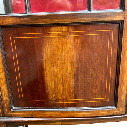 Tapered legs and lower panel detail on an inlaid mahogany display cabinet