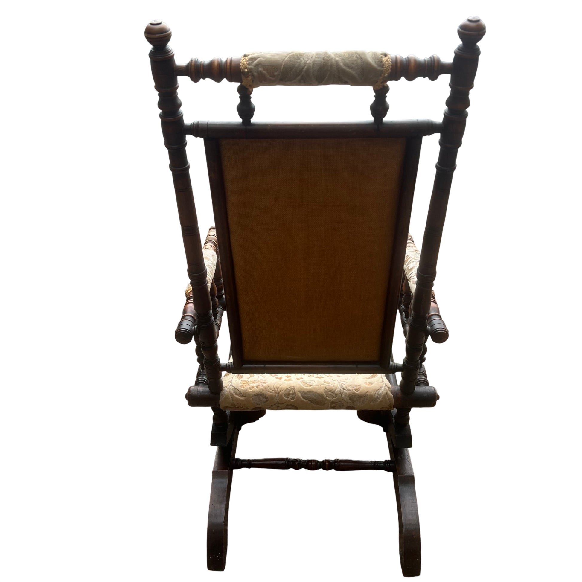 Detail of turned spindle arm supports and padded arm rolls on antique rocker