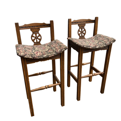 Pair of Old Charm oak bar stools with carved wheel-back and patterned upholstered seats