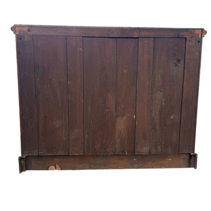 Side view showing fluted upright and carved panel of wooden cupboard