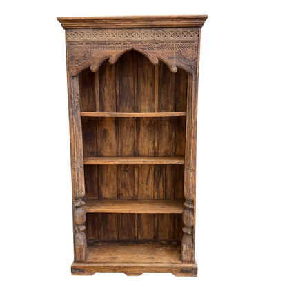 Close view of carved frieze on a tall oak bookcase showing geometric carving