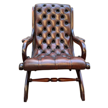 Front view button-tufted brown leather armchair with wooden arms and studded detail