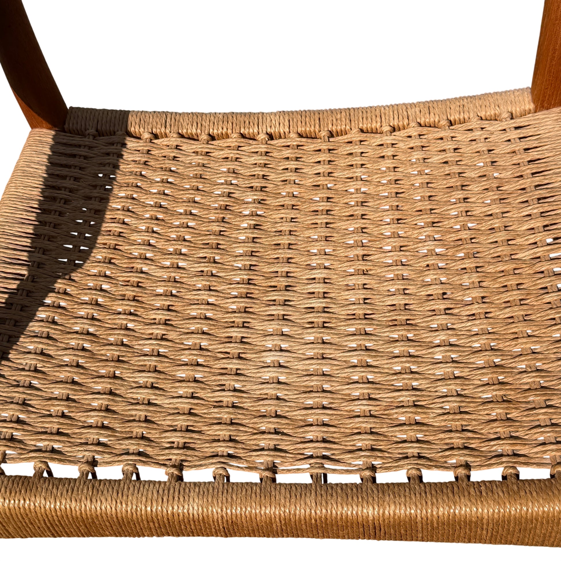 Lower view showing front legs and shadow of chair on paving