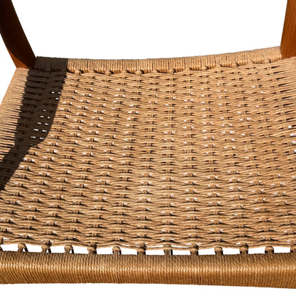 Lower view showing front legs and shadow of chair on paving