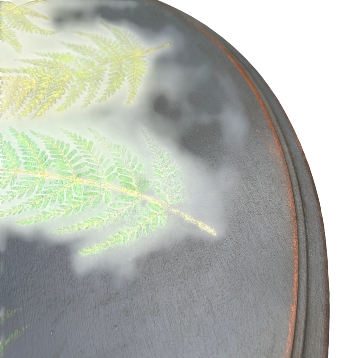 Side view of painted occasional table showing carved legs and worn paint edges