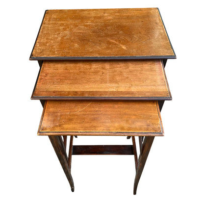 Top view of nesting table set showing pale wooden top with surface scratches