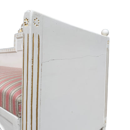 Side view of painted daybed showing turned tapering legs and paint loss